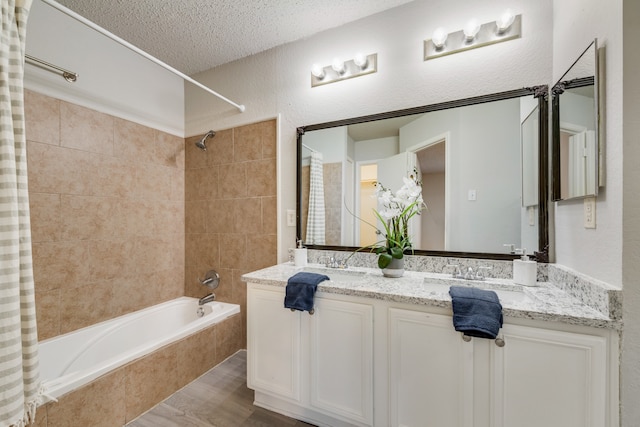 bathroom featuring vanity, hardwood / wood-style floors, shower / tub combo with curtain, and a textured ceiling