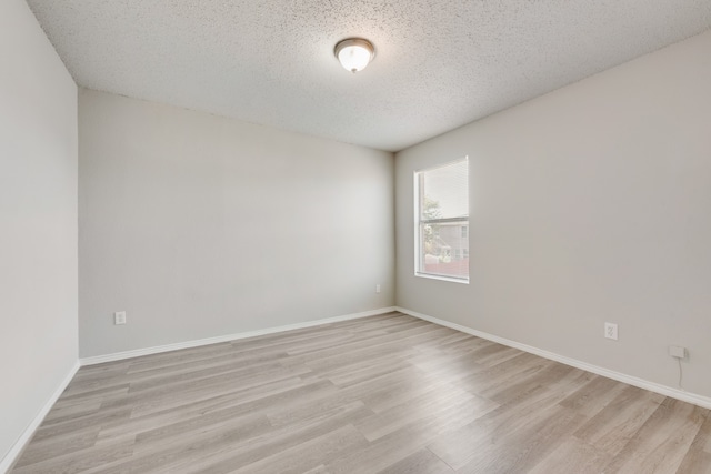 unfurnished room with a textured ceiling and light wood-type flooring