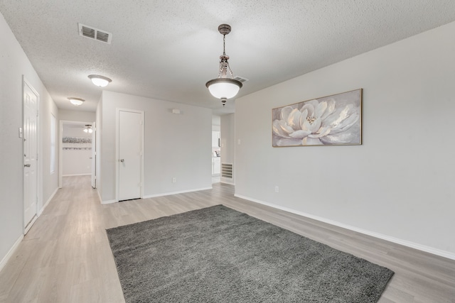 empty room with hardwood / wood-style flooring and a textured ceiling