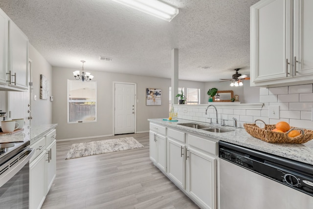 kitchen featuring light stone countertops, sink, backsplash, stainless steel appliances, and white cabinets