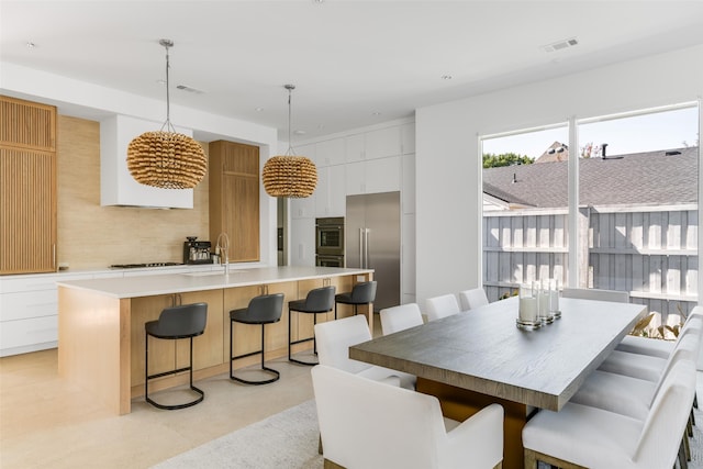 dining space featuring sink and light tile patterned floors