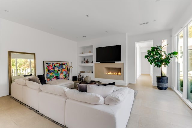 living room featuring light tile patterned floors and built in shelves