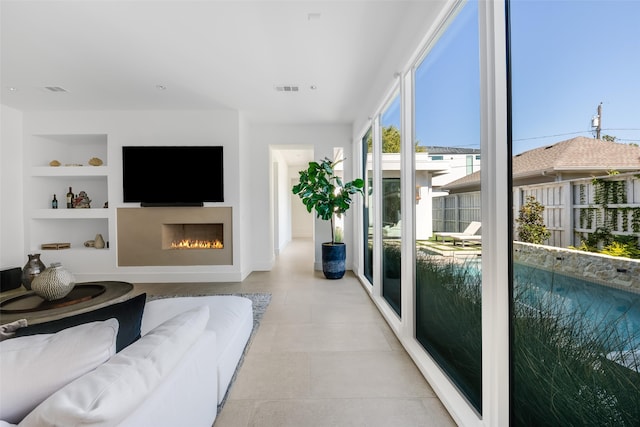 living room featuring built in shelves and light tile patterned floors