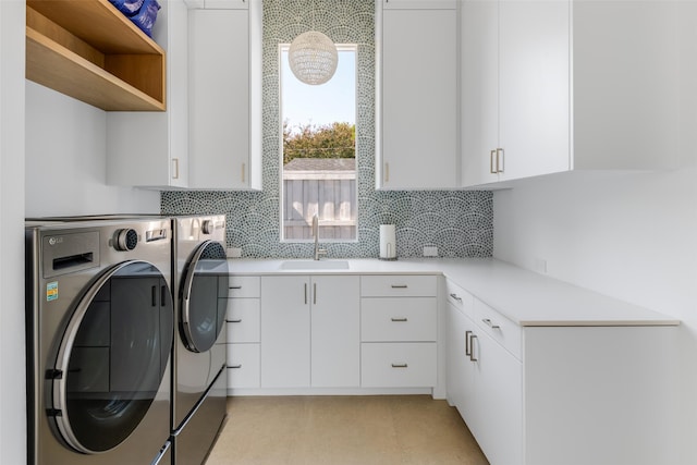 washroom with sink, cabinets, and washer and clothes dryer