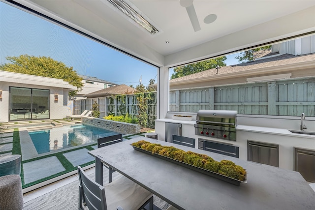 view of swimming pool featuring sink, an outdoor kitchen, and grilling area