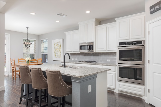 kitchen featuring appliances with stainless steel finishes, dark hardwood / wood-style flooring, and white cabinets