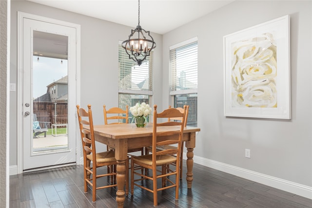 dining area featuring dark hardwood / wood-style floors and an inviting chandelier