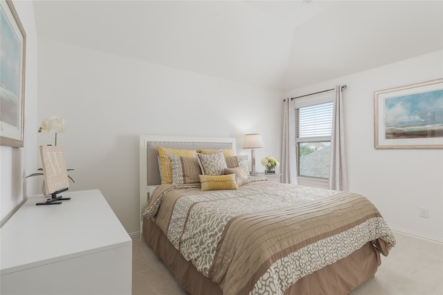 bedroom with light colored carpet and vaulted ceiling