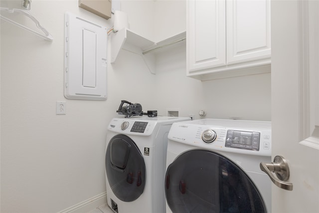 laundry area with electric panel, washing machine and dryer, and cabinets