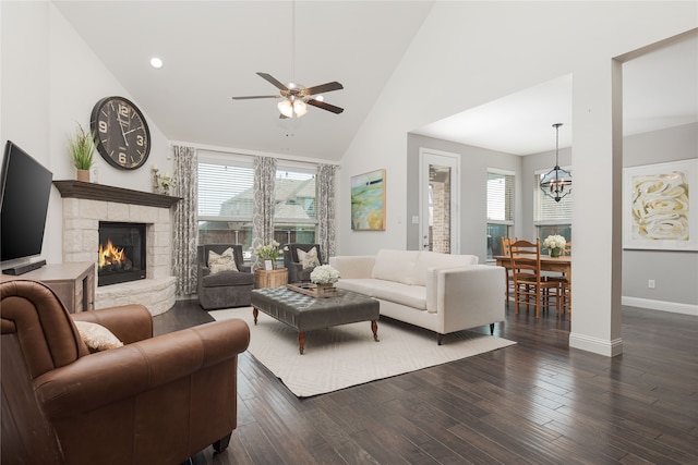 living room with a fireplace, high vaulted ceiling, a healthy amount of sunlight, and dark hardwood / wood-style flooring