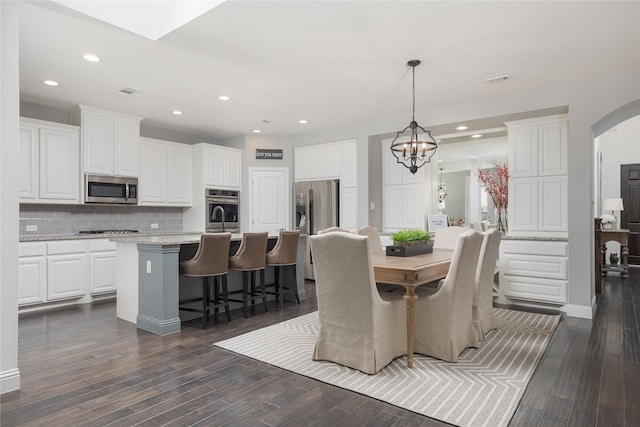 dining room with a notable chandelier and dark hardwood / wood-style floors