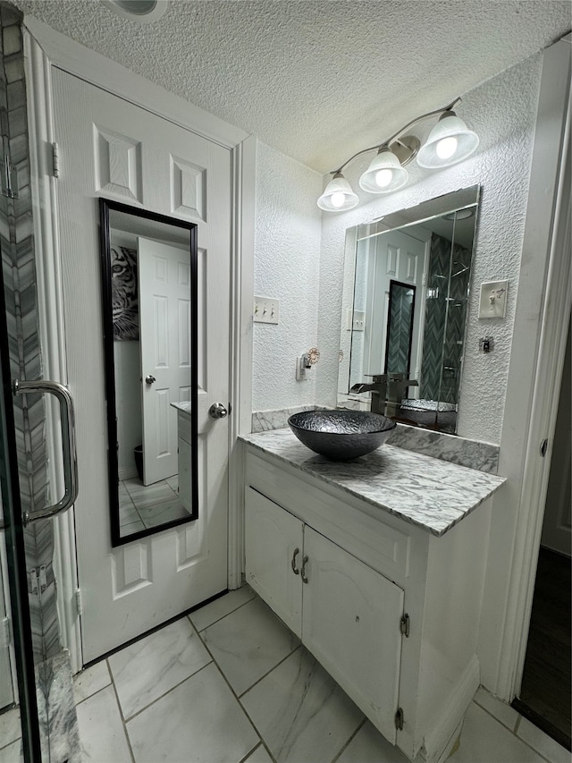 bathroom featuring a textured ceiling and vanity