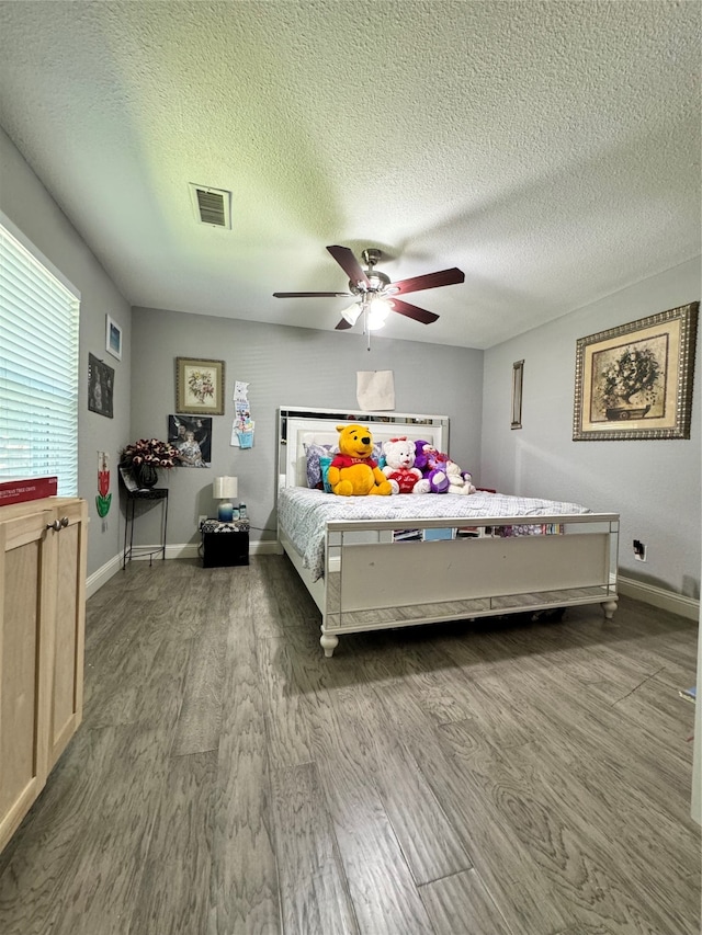 bedroom with hardwood / wood-style floors, a textured ceiling, and ceiling fan