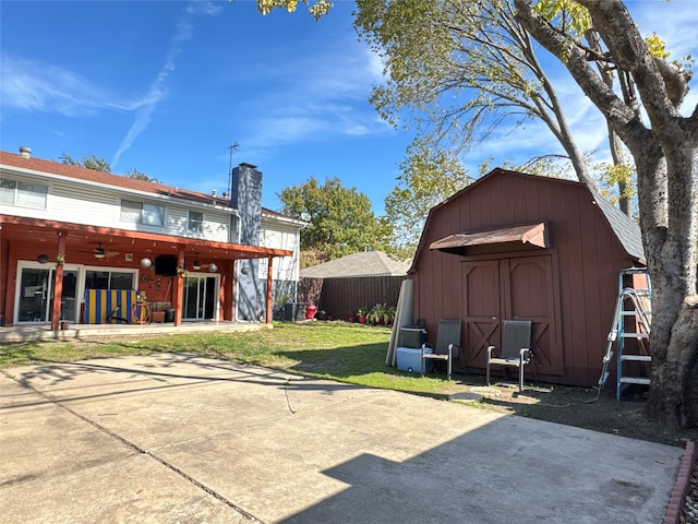 back of house featuring a patio area, ceiling fan, a storage shed, and a lawn