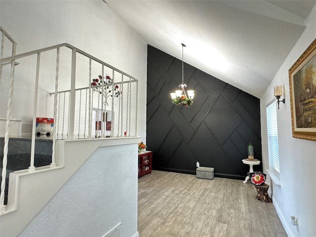 foyer featuring a chandelier, hardwood / wood-style floors, and vaulted ceiling