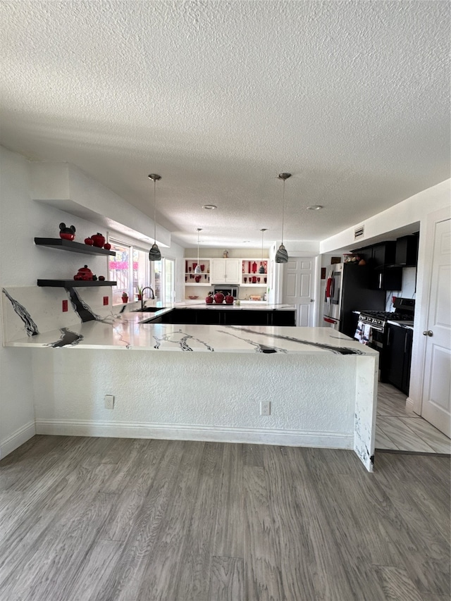 kitchen featuring hardwood / wood-style floors, a textured ceiling, and hanging light fixtures