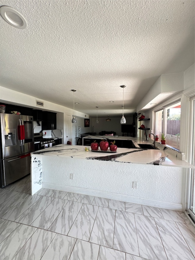 kitchen with stainless steel fridge with ice dispenser, a textured ceiling, and decorative light fixtures