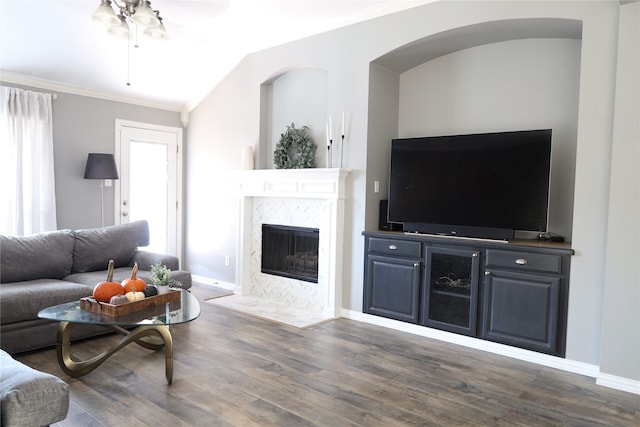 living room featuring a high end fireplace, crown molding, vaulted ceiling, dark hardwood / wood-style flooring, and ceiling fan