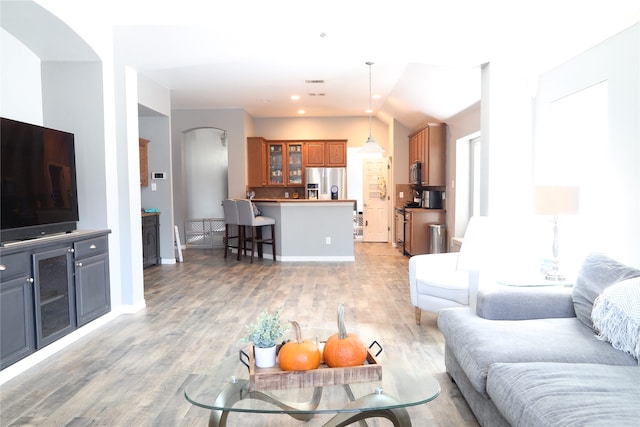 living room featuring lofted ceiling and hardwood / wood-style flooring