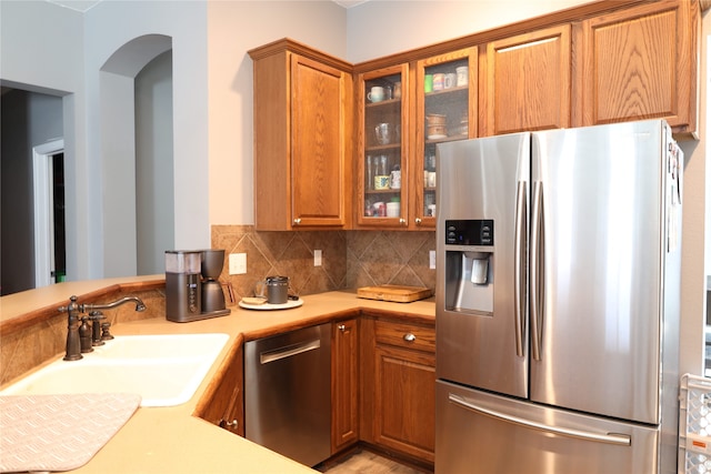 kitchen featuring sink, appliances with stainless steel finishes, and decorative backsplash