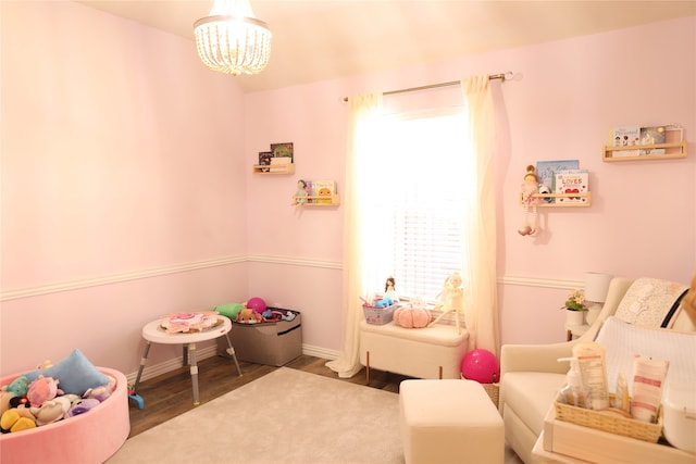 rec room with a chandelier and hardwood / wood-style flooring