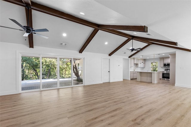 unfurnished living room with light hardwood / wood-style flooring, beam ceiling, sink, and high vaulted ceiling