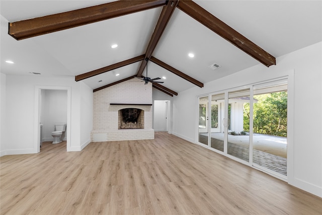 unfurnished living room with light hardwood / wood-style floors, lofted ceiling with beams, a fireplace, and ceiling fan