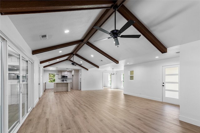 unfurnished living room featuring a textured ceiling, light hardwood / wood-style flooring, vaulted ceiling with beams, and an inviting chandelier