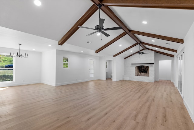 unfurnished living room with lofted ceiling with beams, light hardwood / wood-style flooring, a wealth of natural light, and a fireplace