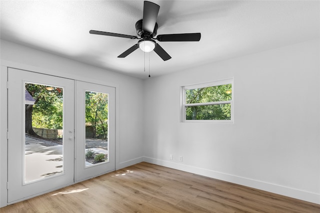 unfurnished room with light wood-type flooring, a healthy amount of sunlight, and ceiling fan