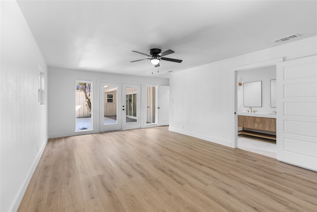 unfurnished living room featuring light hardwood / wood-style floors, french doors, sink, and ceiling fan