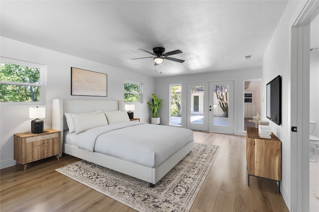 bedroom with wood-type flooring, french doors, a textured ceiling, access to exterior, and ceiling fan