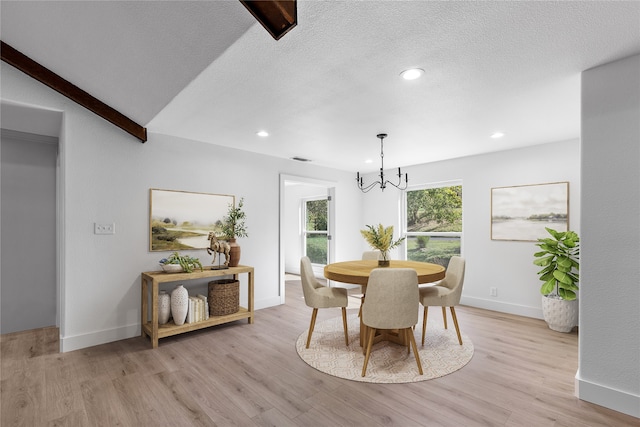 dining space with beamed ceiling, a notable chandelier, a textured ceiling, and light wood-type flooring