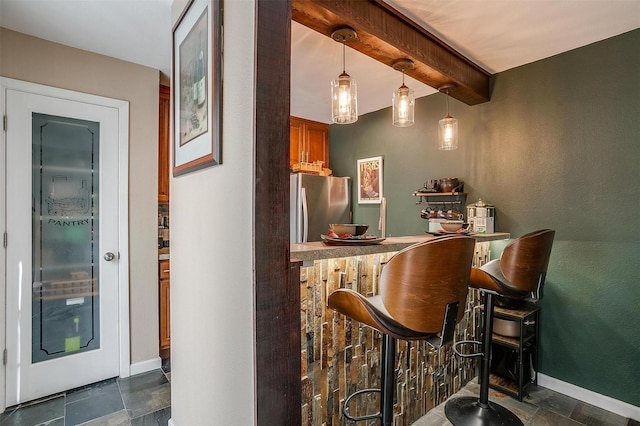 bar with pendant lighting, stainless steel refrigerator, and beam ceiling