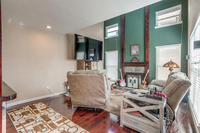 living area with a towering ceiling and dark hardwood / wood-style floors