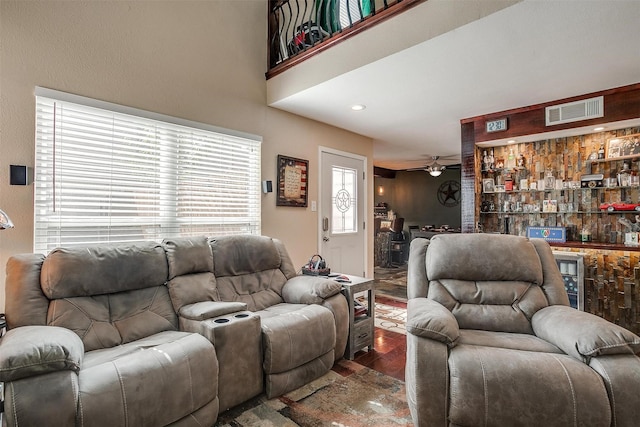 living room with ceiling fan and dark wood-type flooring