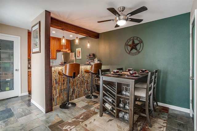 dining space featuring beamed ceiling and ceiling fan