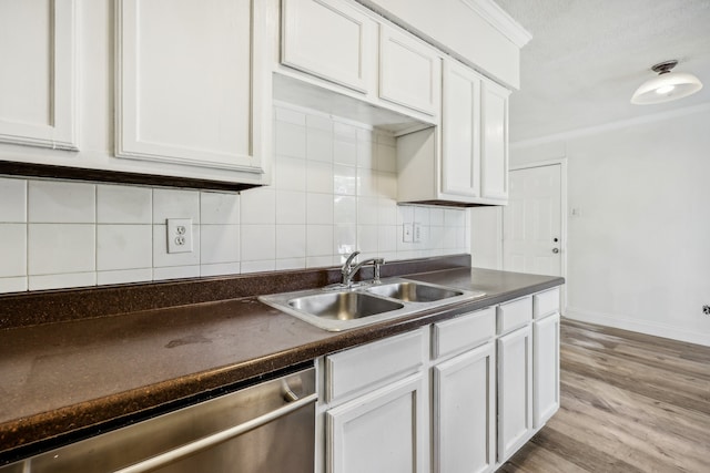 kitchen featuring decorative backsplash, sink, light hardwood / wood-style flooring, dishwasher, and white cabinetry