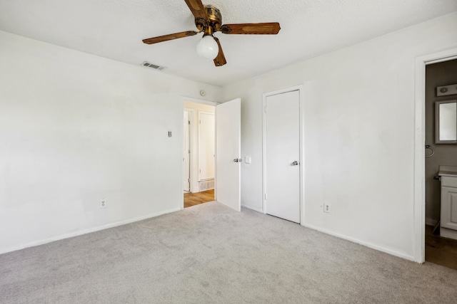 unfurnished bedroom featuring light carpet, connected bathroom, and ceiling fan