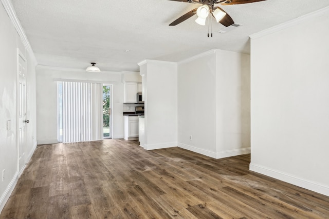 unfurnished living room featuring a textured ceiling, crown molding, and dark wood-type flooring