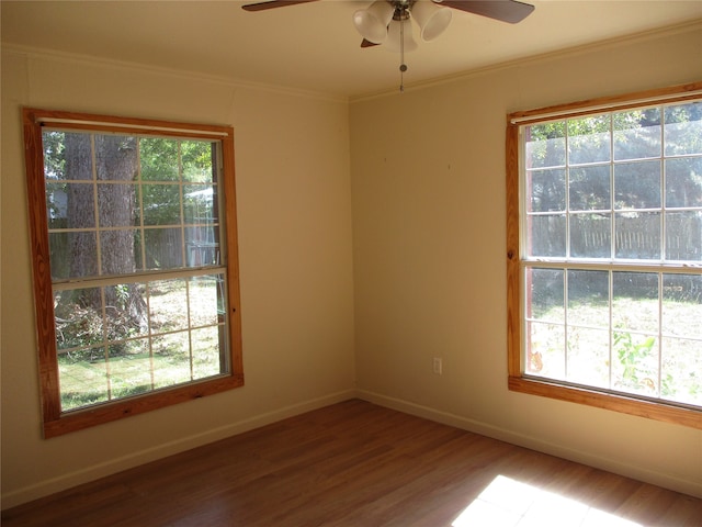 unfurnished room featuring a wealth of natural light, hardwood / wood-style floors, crown molding, and ceiling fan