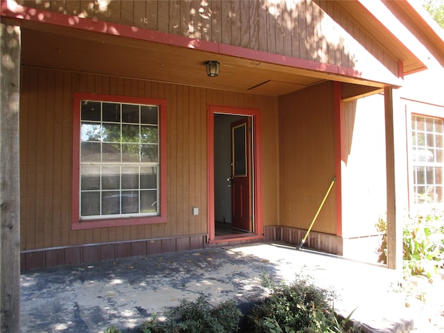 view of exterior entry with a patio