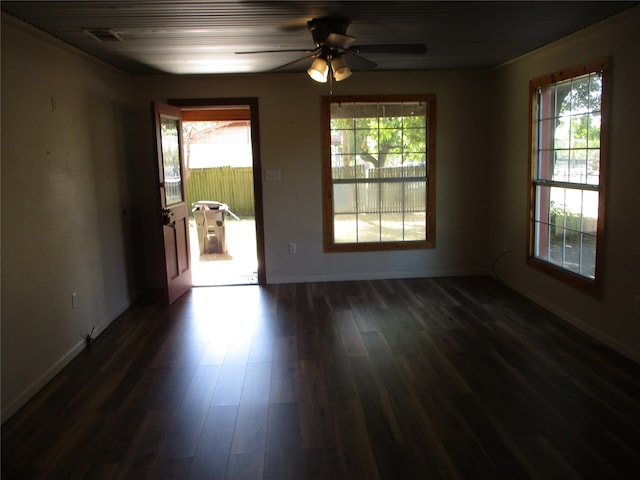 spare room featuring dark hardwood / wood-style flooring, ceiling fan, and a wealth of natural light