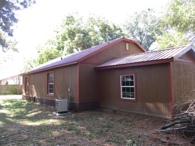 view of property exterior featuring central air condition unit and a lawn