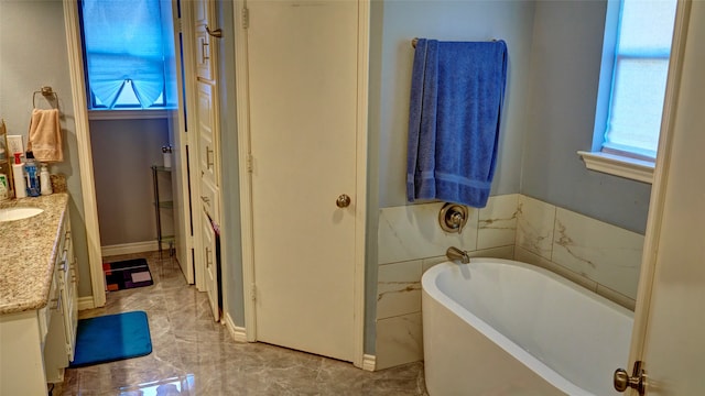 bathroom featuring vanity and a tub to relax in