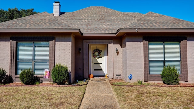 property entrance with a lawn