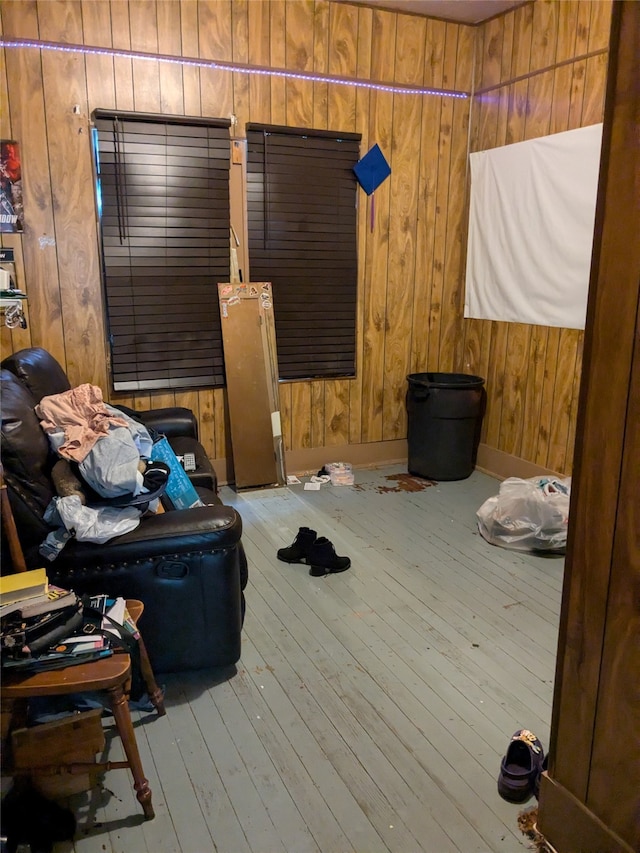 bedroom with light hardwood / wood-style floors and wooden walls