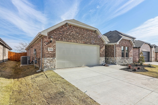 view of front of property featuring a garage and central air condition unit