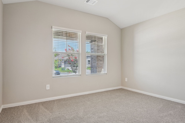 carpeted spare room with vaulted ceiling