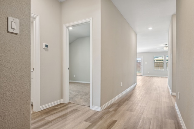 hall with light wood-type flooring and baseboards